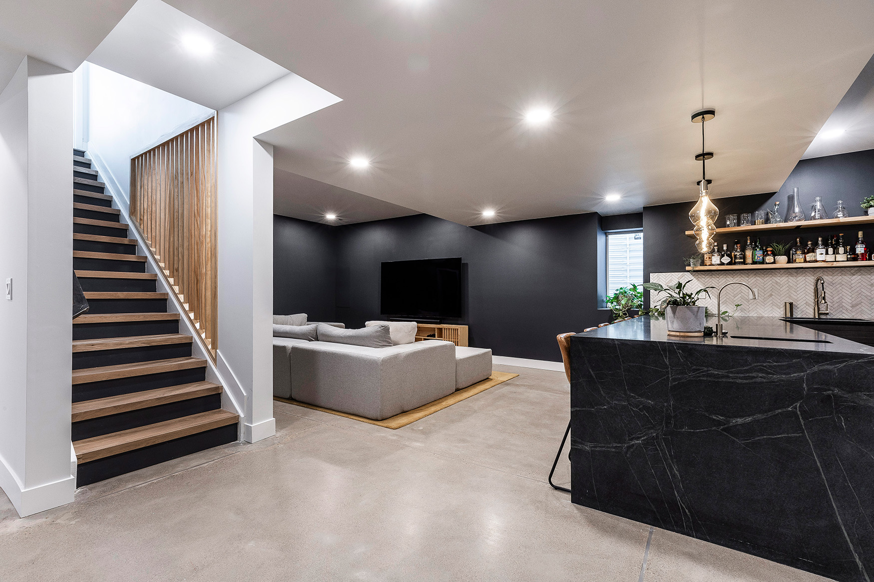 Finished basement living area with modern bar and staircase, BCT Contractors renovation.
