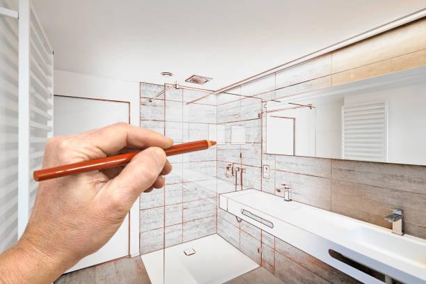 Basement renovation design sketch with hand holding pencil and modern bathroom concept.
