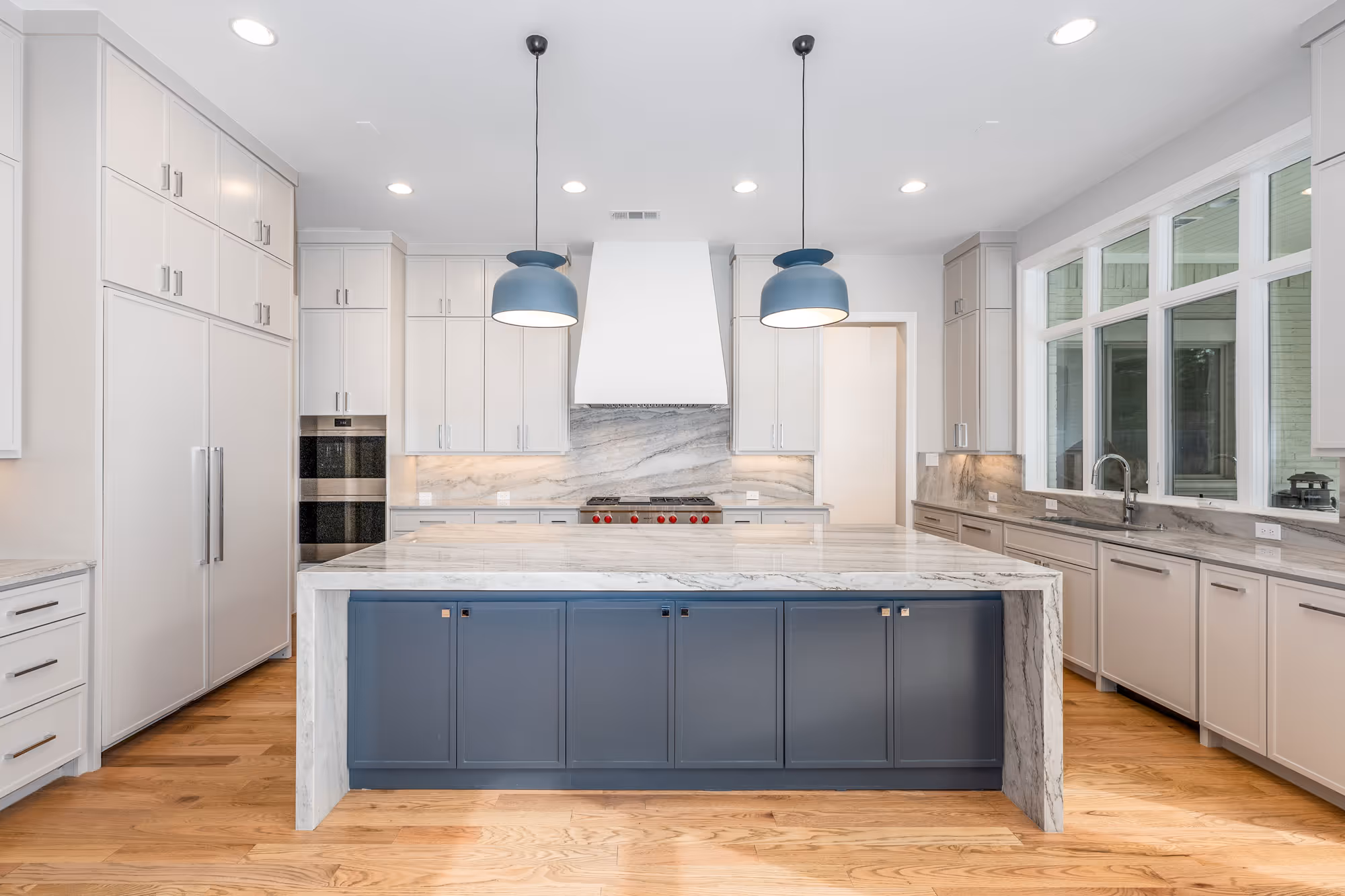 Modern kitchen renovation with custom cabinets, quartz countertops, and a large island by BCT Contractors.